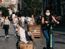 man in black t-shirt and blue denim jeans sitting on brown wooden bench {{brizy_dc_image_alt entityId=
